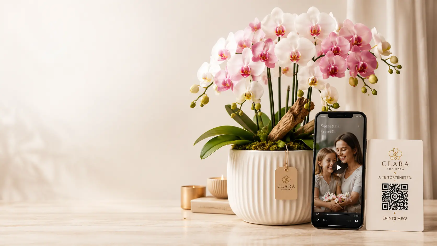 Kézzel készített fehér orchidea kaspóban, mellette telefon videóüzenettel és QR-kártya